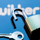 An open security lock and key on the background of the Twitter social network logo in the mirror reflection.